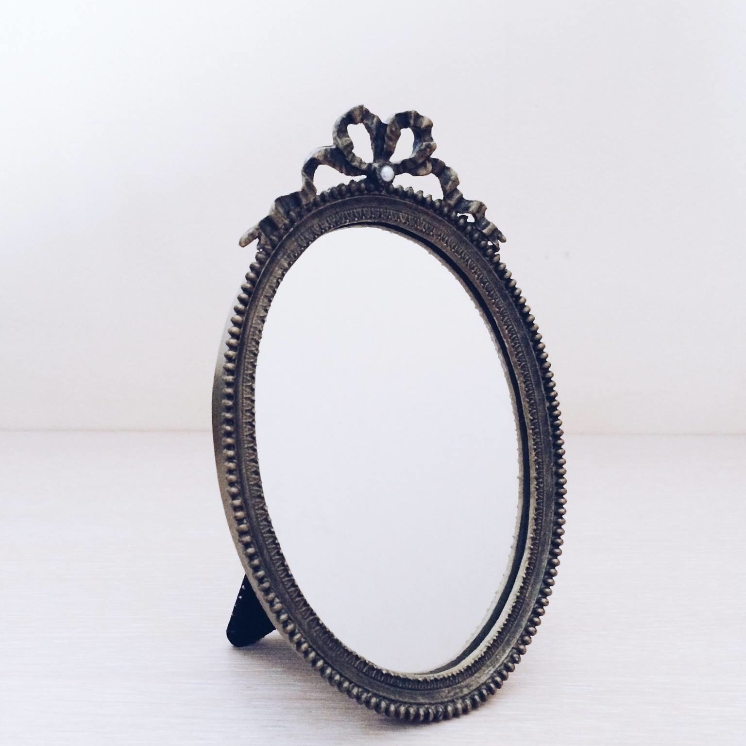 Дзеркало овальне мале в металевій рамкі з декоративним бантом