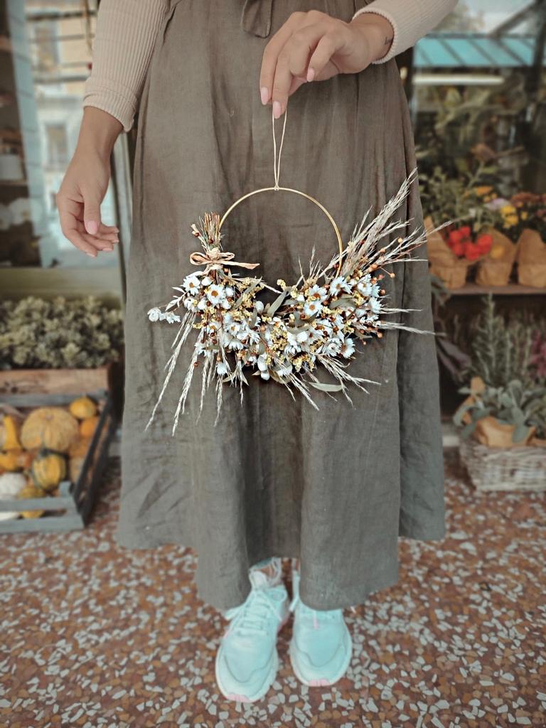 ghirlanda di fiori secchi dai colori pastello intrecciati su una base elegante di ottone