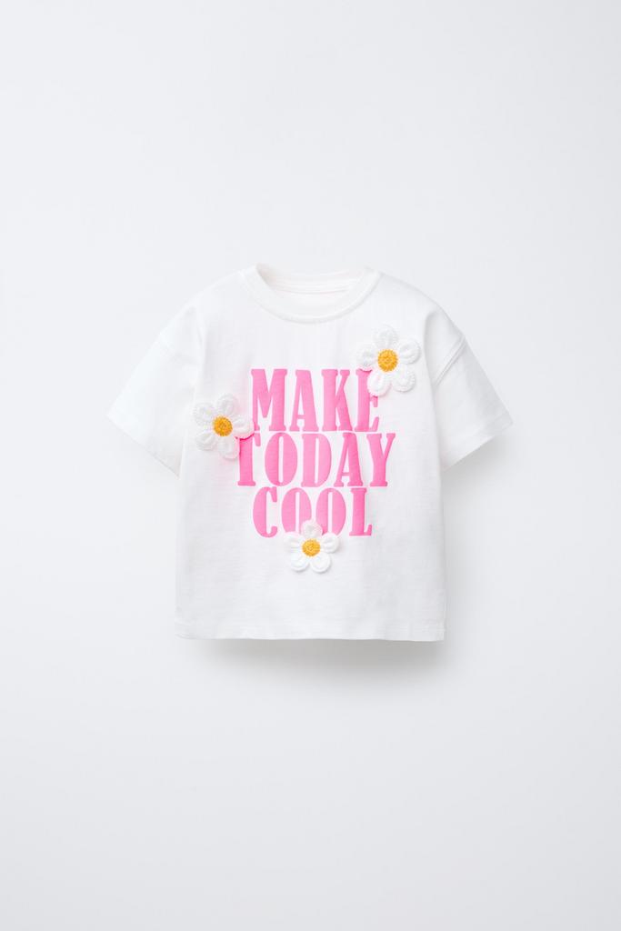 Футболка з написом та аплікаціями у вигляді квітів
