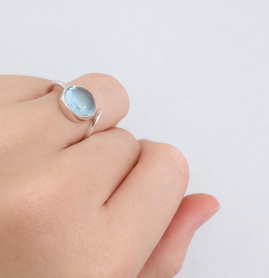 Bague en argent avec topaze bleue cabochon rond