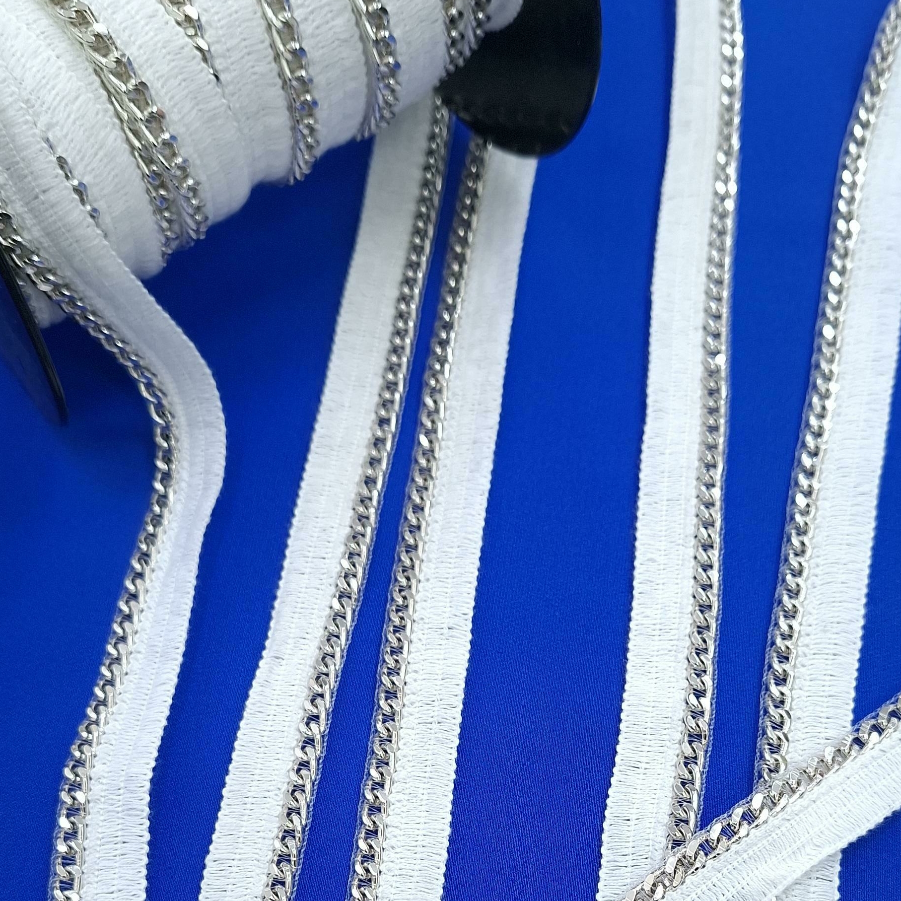 Серебристая цепочка на белой тесьме